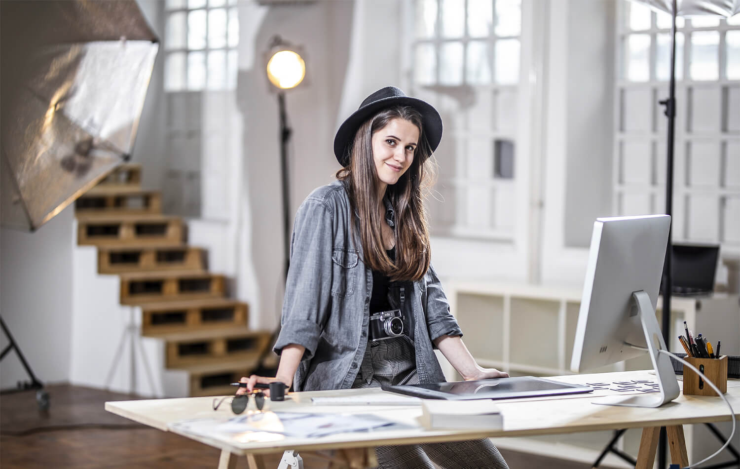 Woman designer standing next to a work table in a studio. Human factor drives innovation.